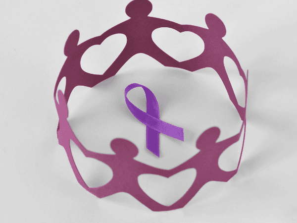 Paper chain of people surrounding a purple ribbon