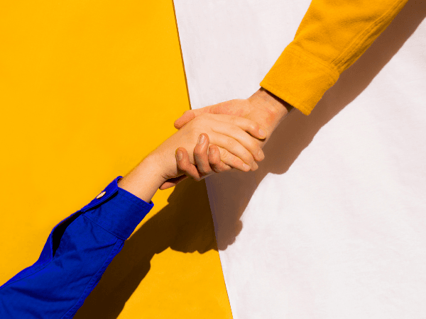 Hand reaching out and holding another hand